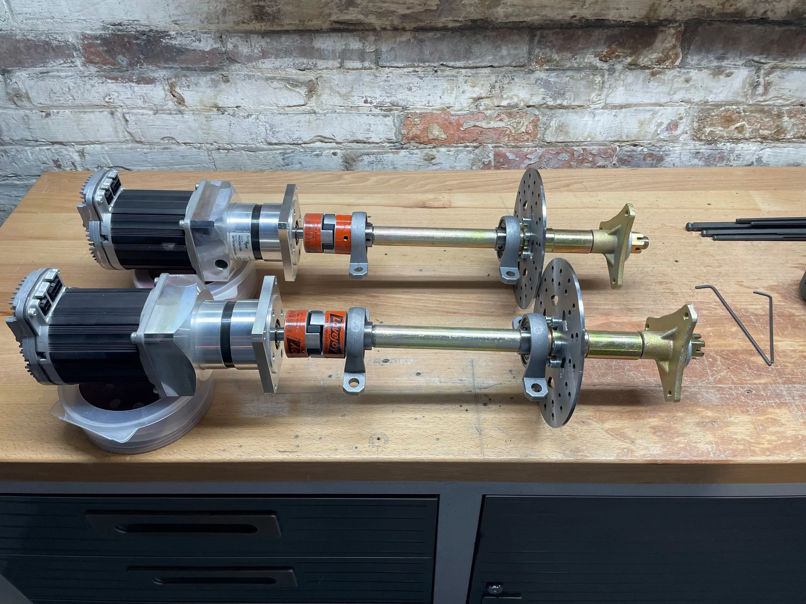 Two identical drive assemblies side by side on a workbench