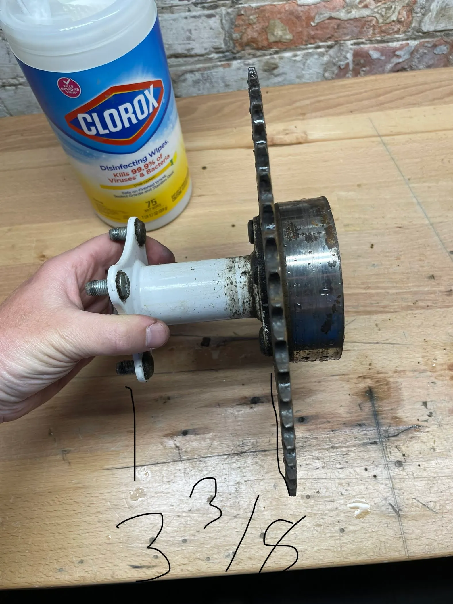 The hub bolted to the sprocket and held edge-on, annotated 3 3/8 inches