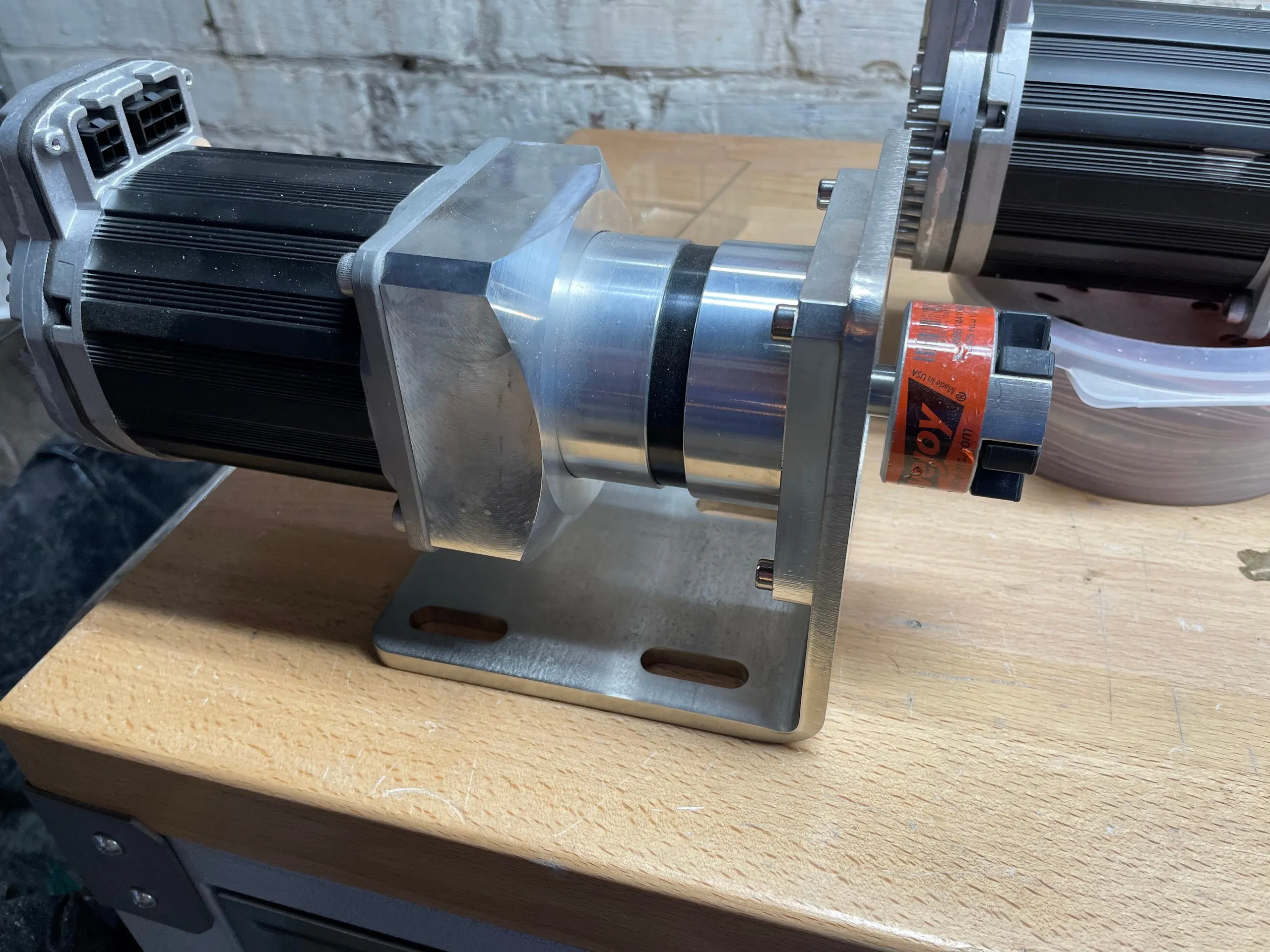 A ClearPath motor bolted to a gearbox and a machined mounting bracket, on a workbench