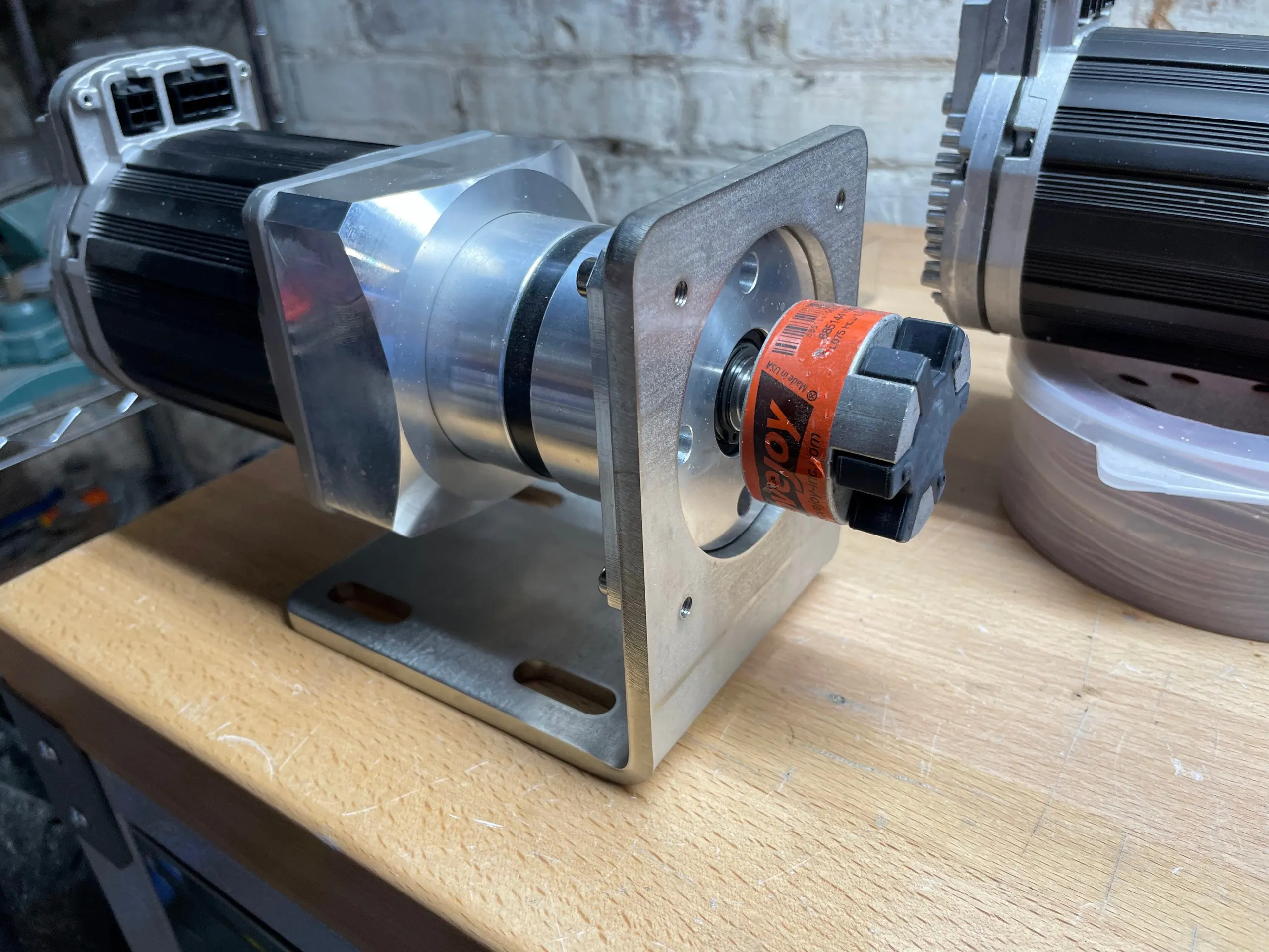 The same assembly from the output end, showing the gearbox output shaft in an orange jaw coupling