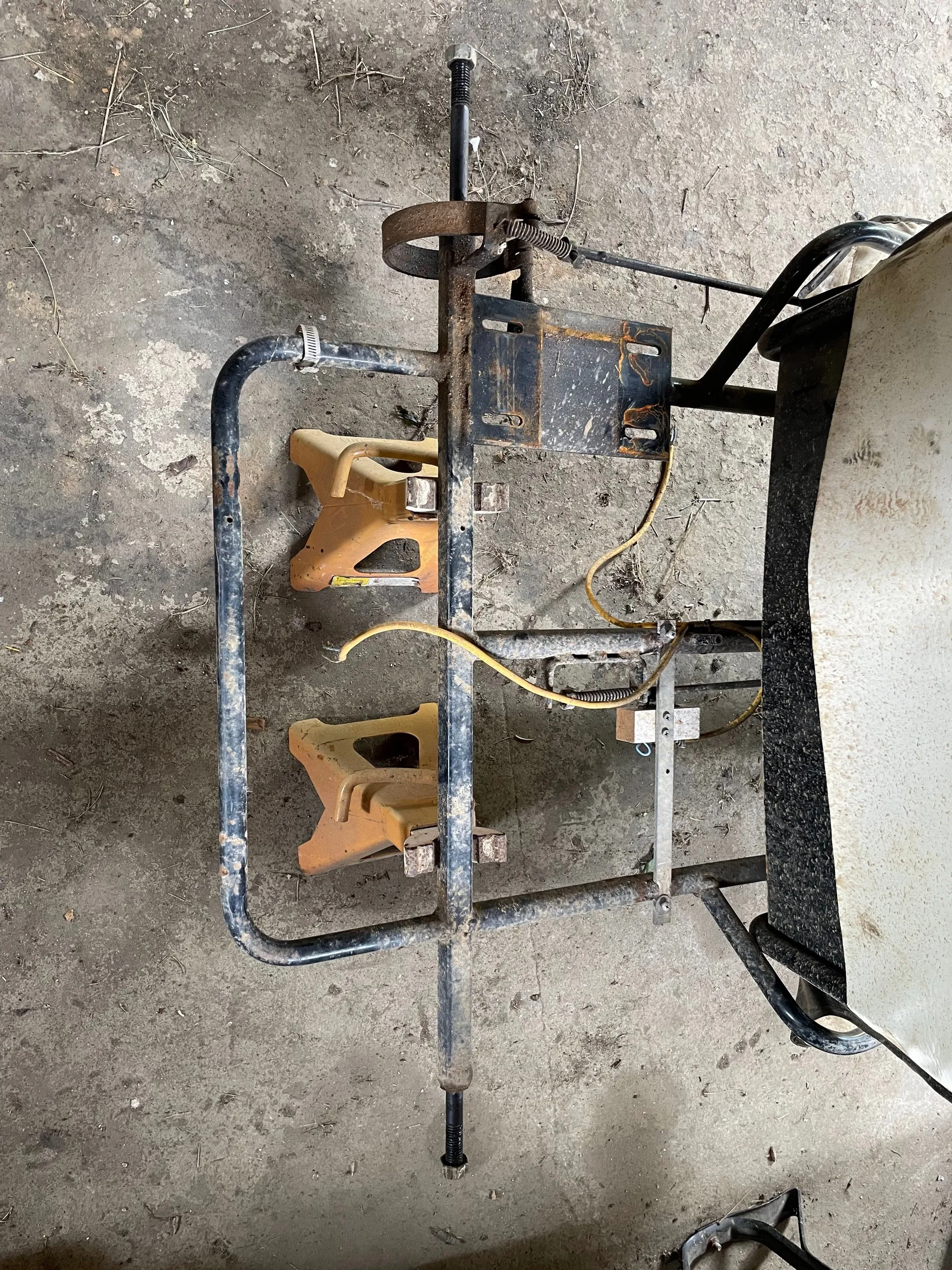 The go-kart chassis upside down on jack stands with the rear axle, sprocket and brake band still fitted