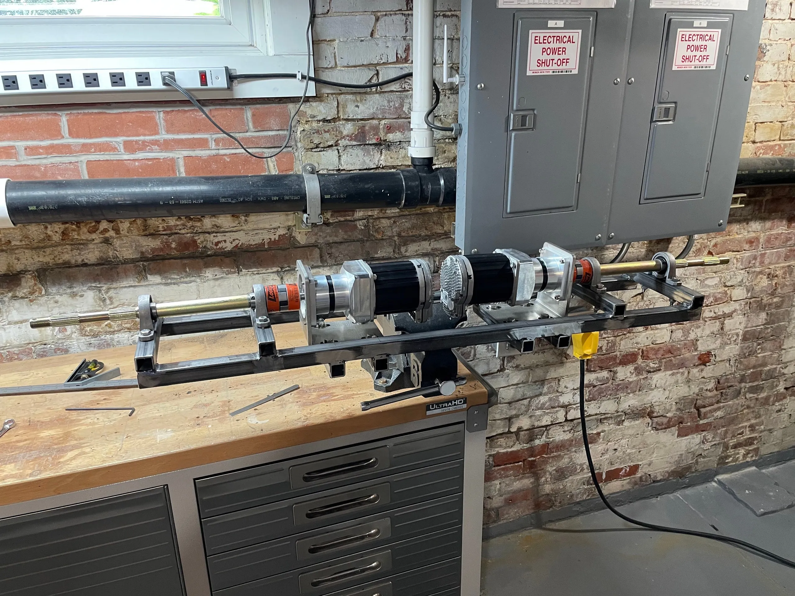 The subframe clamped in a vise with both drives, shafts, couplings and brake discs installed