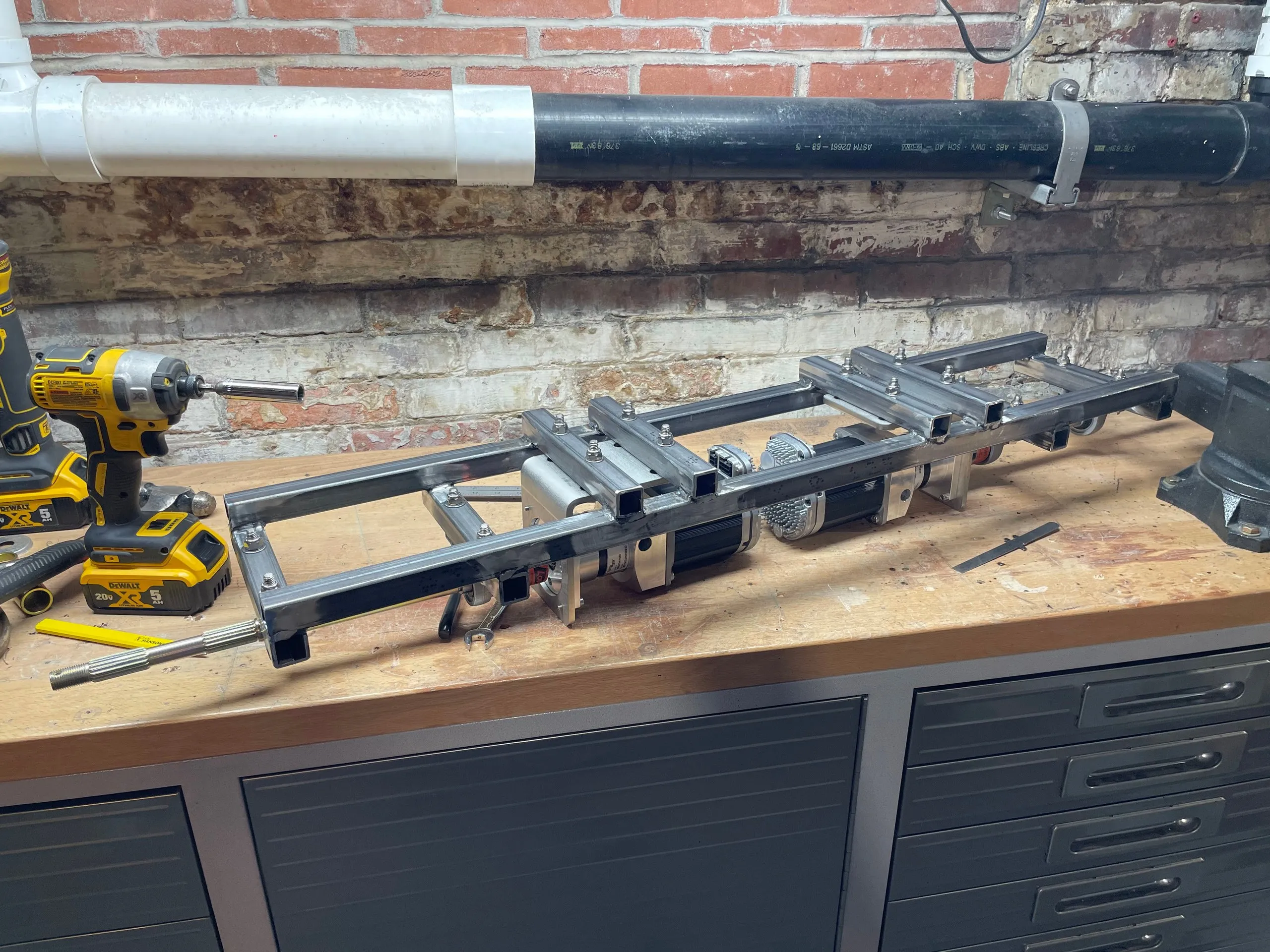 The subframe on a workbench with both motors and gearboxes mounted in the middle