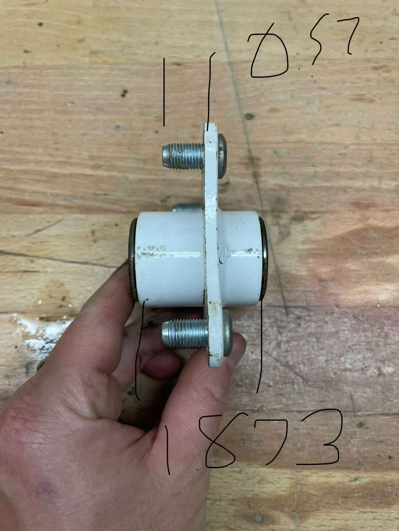 The hub photographed edge-on and held in a hand, annotated 0.57 and 1.873